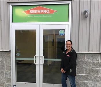 female employee posing at servpro storefront