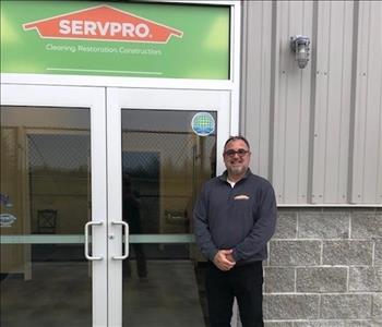 male employee posing at servpro store front