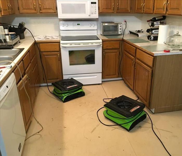 Two stackable SERVPRO air movers operating on a kitchen floor