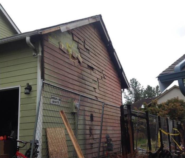 outside of a home with fire damage to the siding